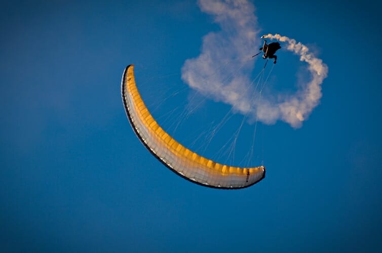 paragliding doing tricks with smoke