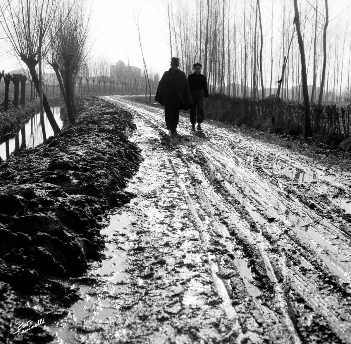 persone su strada infangata